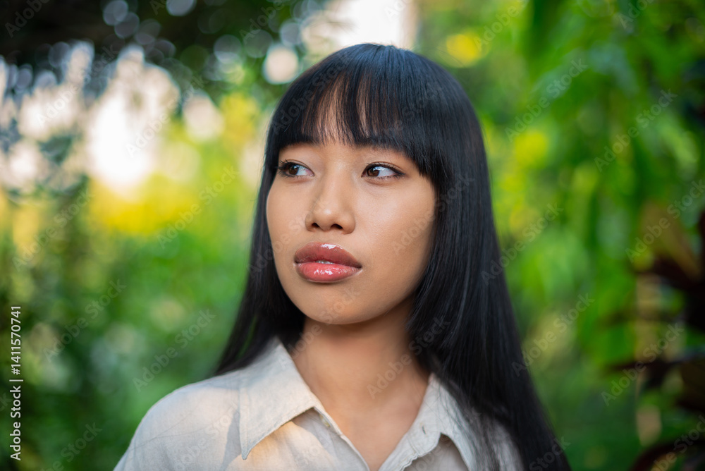 Elegant asian woman looking into the distance in nature, looking serene and thoughtful Elegant asian woman looking into the distance in nature, looking serene and thoughtful