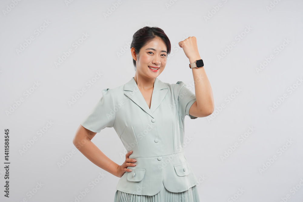 Cheerful woman with a smart watch pumps her fist in the air expressing success and empowerment Cheerful woman with a smart watch pumps her fist in the air expressing success and empowerment