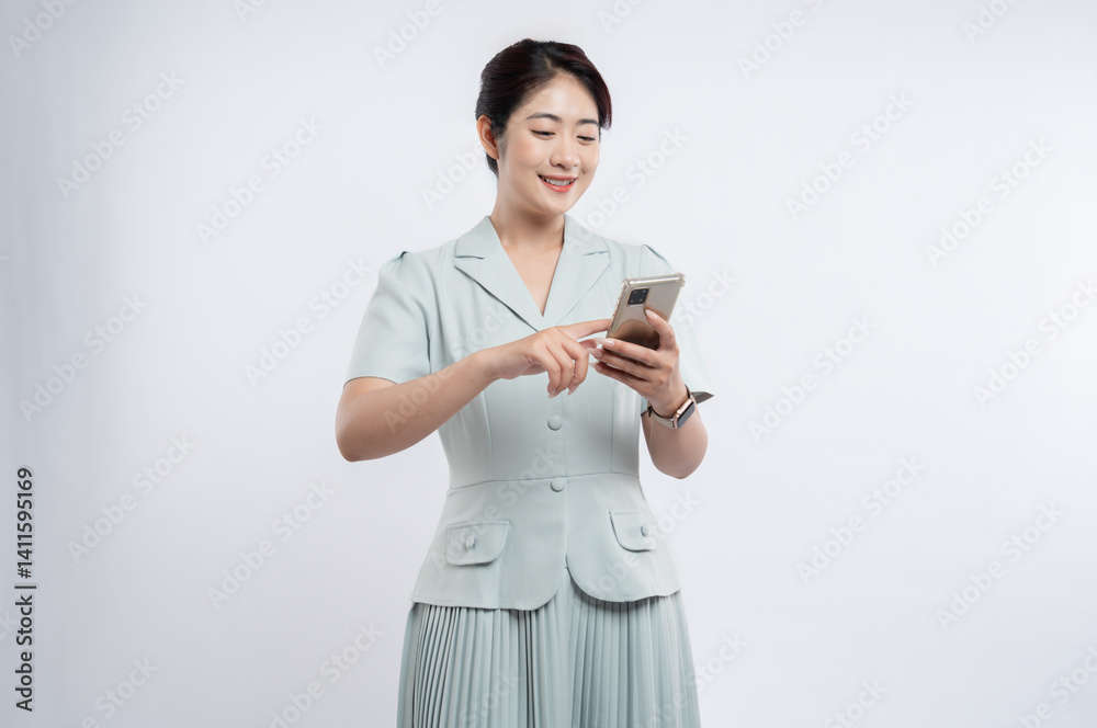 A stylish Asian woman smiles while interacting with a smart phone dressed in a vintage suit A stylish Asian woman smiles while interacting with a smart phone dressed in a vintage suit