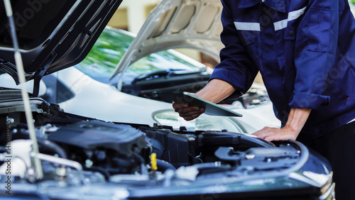 Auto mechanic hands using wrench to repair auto engine. Car maintenance, service at garage. Technician inspects vehicle for problems. Auto repair, fixing, check, services, insurance, checkup concept.