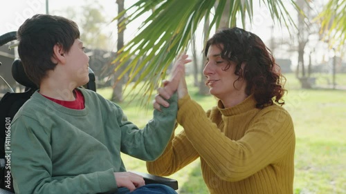 Disabled child interacting with therapist in park photo