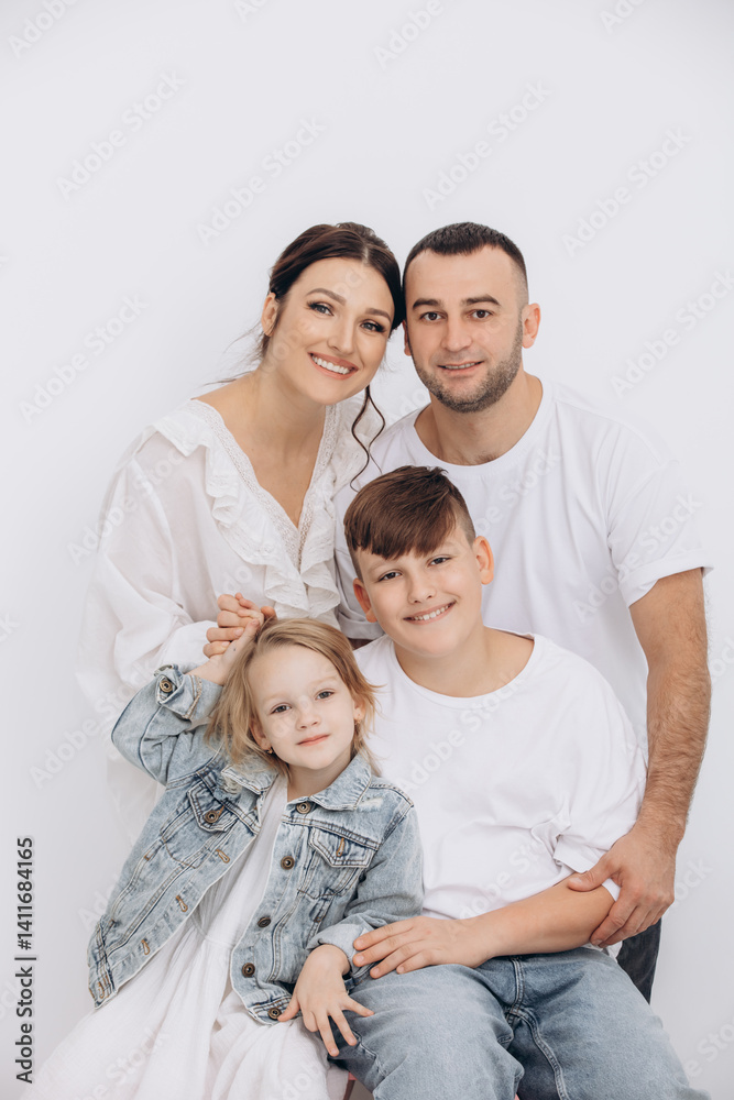 The family is beautiful and happy, mother, father, son and daughter together portrait on a white background