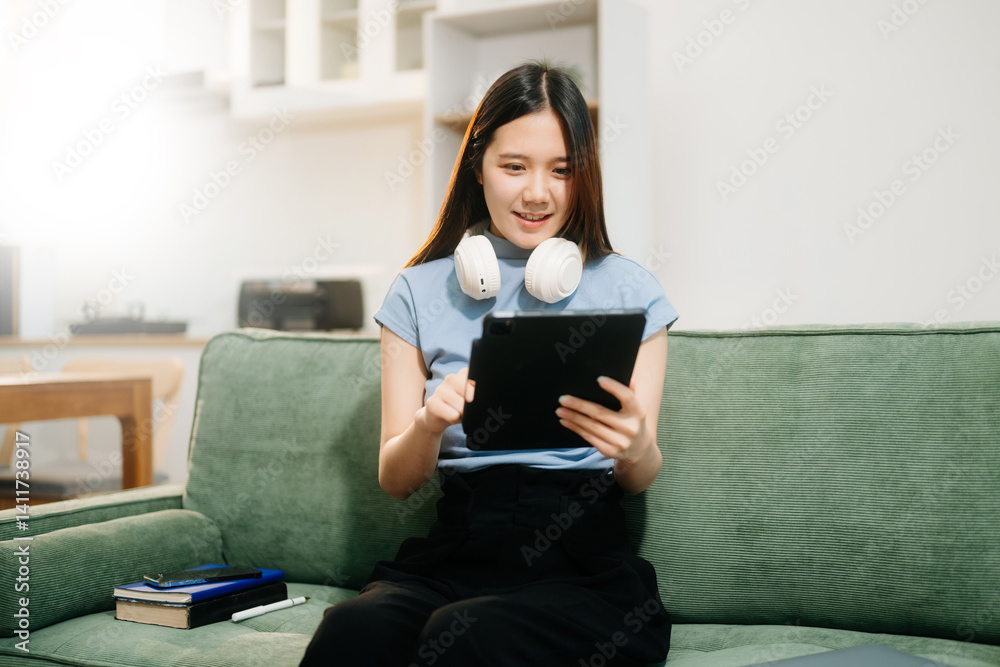 Young asian woman relax on comfortable couch at home texting messaging on smartphone and tablet Young asian woman relax on comfortable couch at home texting messaging on smartphone and tablet