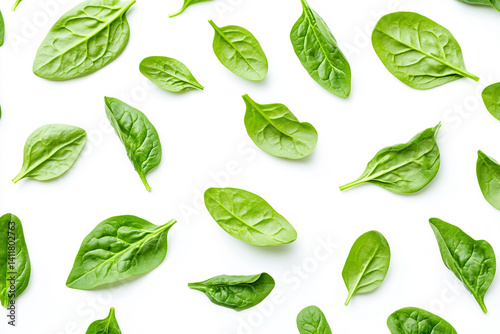 Fresh green spinach leaves scattered on white background healthy food pattern