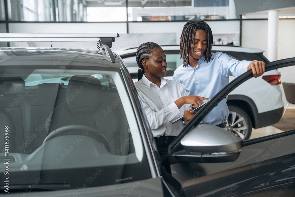 Documents in hands. Car seller is assisting client in the automobile salon Documents in hands. Car seller is assisting client in the automobile salon