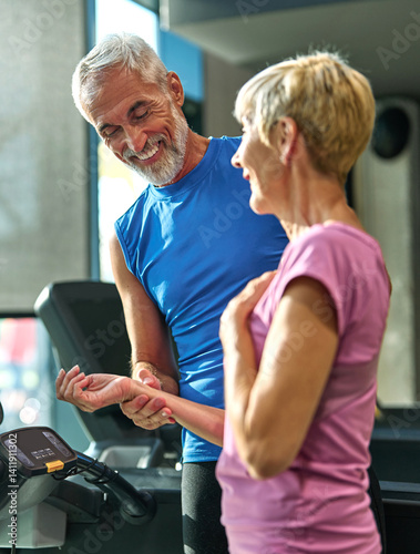 gym sport fitness exercising training mature woman coach pulse cardio health care hand checking heartbeat check blood pressure rate running treadmill healthy active