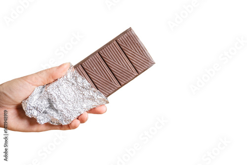 a bar of delicious chocolate in a woman's hand on a light background.