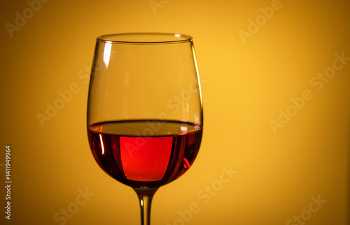 glass of pink wine on a colored background.