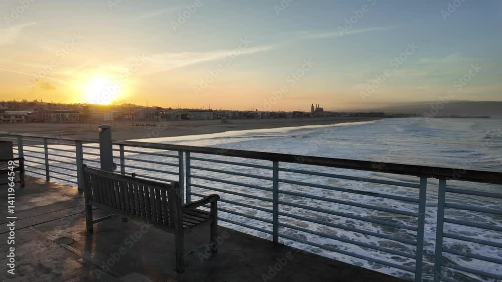 Scenic view of the ocean waves splashing on the beach from pier at golden hour Scenic view of the ocean waves splashing on the beach from pier at golden hour