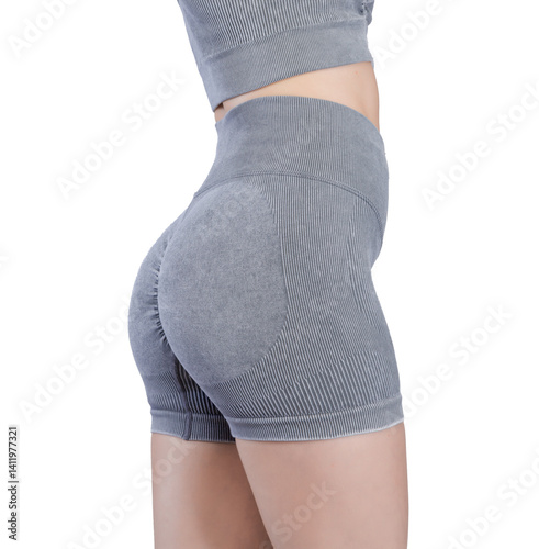Obraz na płótnie Studio shot of a fit woman's lower body from the back, showcasing her toned buttocks and legs. She is wearing a grey ribbed seamless sports bra and high-waisted shorts. w salonie