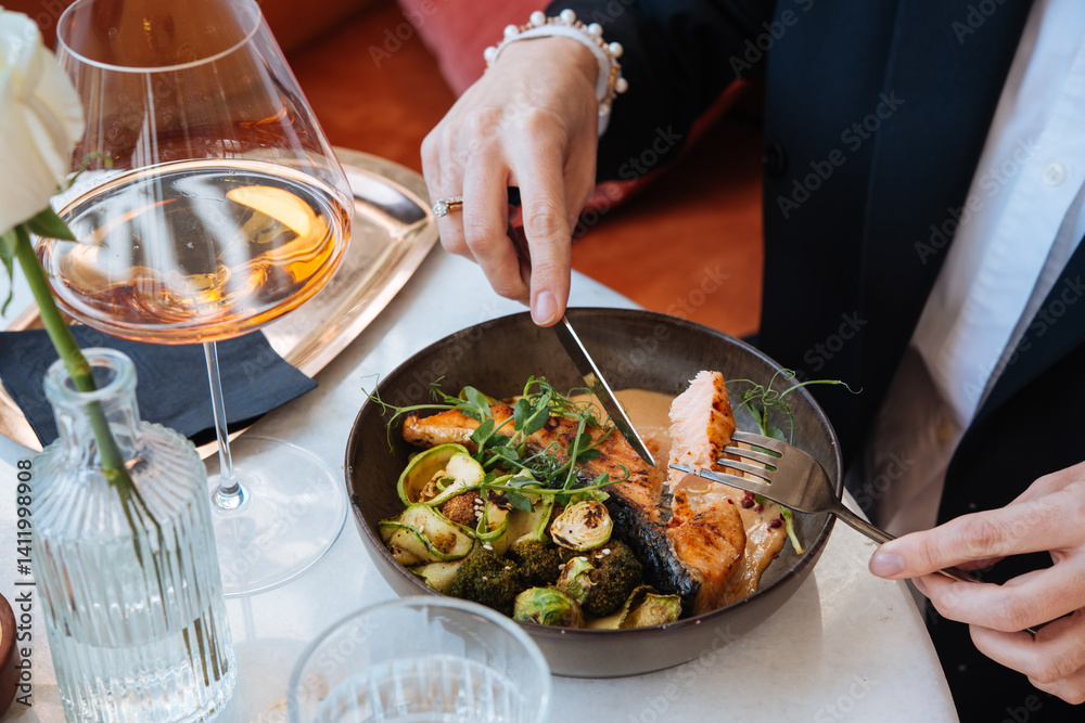 Grilled salmon with brussels sprouts and broccoli served for a dinner in a restaurant.