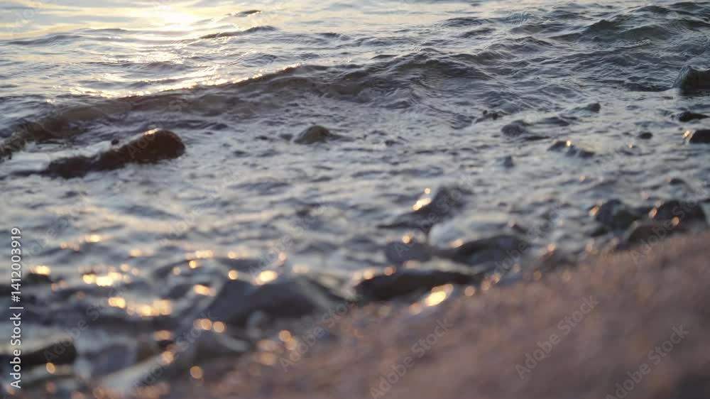 Sunset light hitting waves on beach close-up 4K