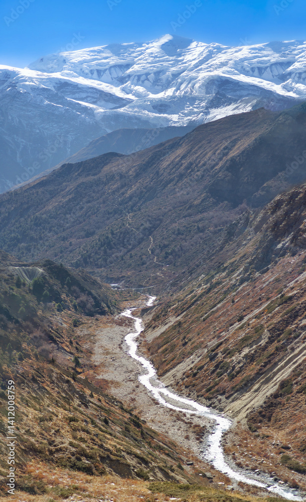 Himalayas, Nepal - The famous hiking on the roof of the world called Annapurna Circuit in the Himalaya range mountain, with little village, buddhist stupa and mountains of 8000 meters.