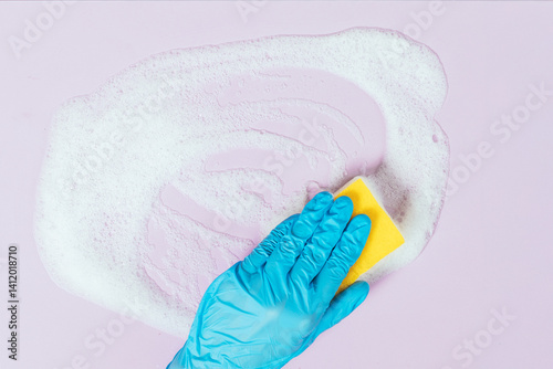 Obraz na płótnie A person is cleaning a surface with a sponge and a blue glove w salonie