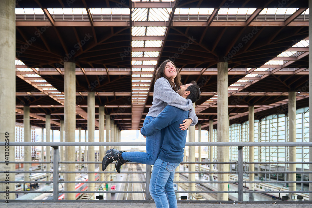Fototapeta premium Happy tourist couple embracing at the train station