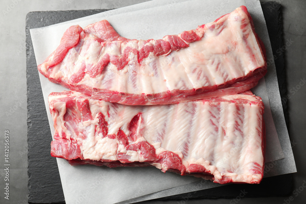 Raw pork ribs on grey table, top view