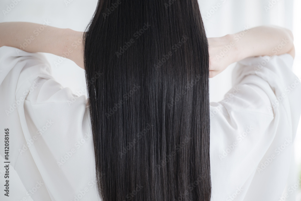 Fototapeta premium 艶のあるロングヘアの黒髪の女性の後ろ姿の顔無し キューティクルな美しいストレートヘアの髪の毛 ヘアケアなどのイメージ 