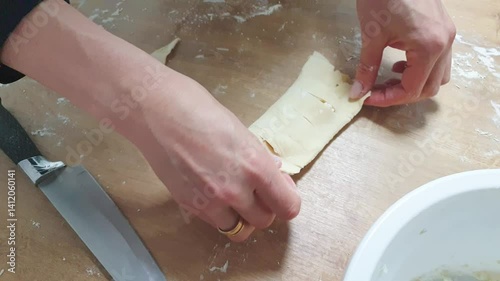 Woman cuts the dough and stuffs the pastry with cottage cheese. Baking