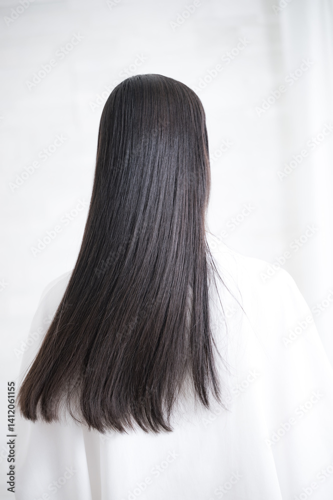 Naklejka premium 艶のあるロングヘアの黒髪の女性の後ろ姿の顔無し キューティクルな美しいストレートヘアの髪の毛 ヘアケアなどのイメージ