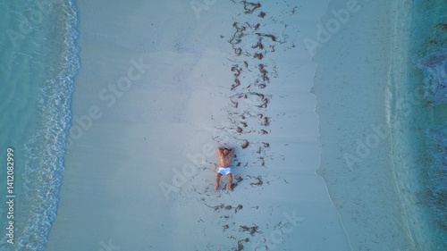 Aerial view of a man lying on the sandbank of Dhigurah in the Maldives