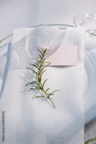 Wedding. Plates with napkins and sprigs of rosemary are set on the festive table.