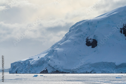 Obraz na płótnie A tranquil Antarctic landscape, near Graham passage along Charlotte Bay, highlighting stark reflections, rugged mountains, and impressive icebergs. w salonie