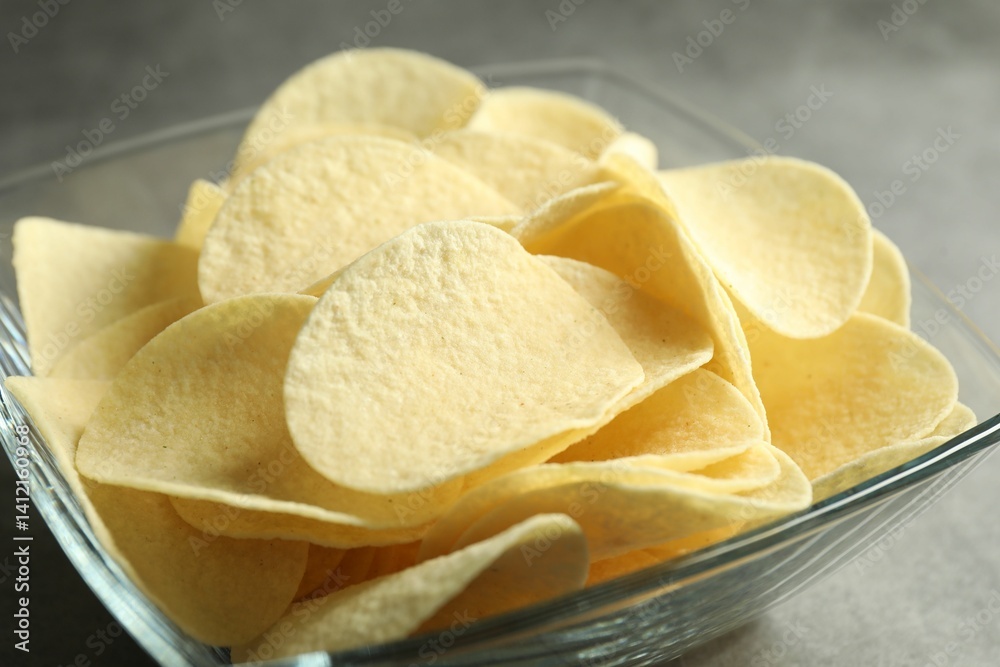 Tasty potato chips on grey table, closeup Tasty potato chips on grey table, closeup