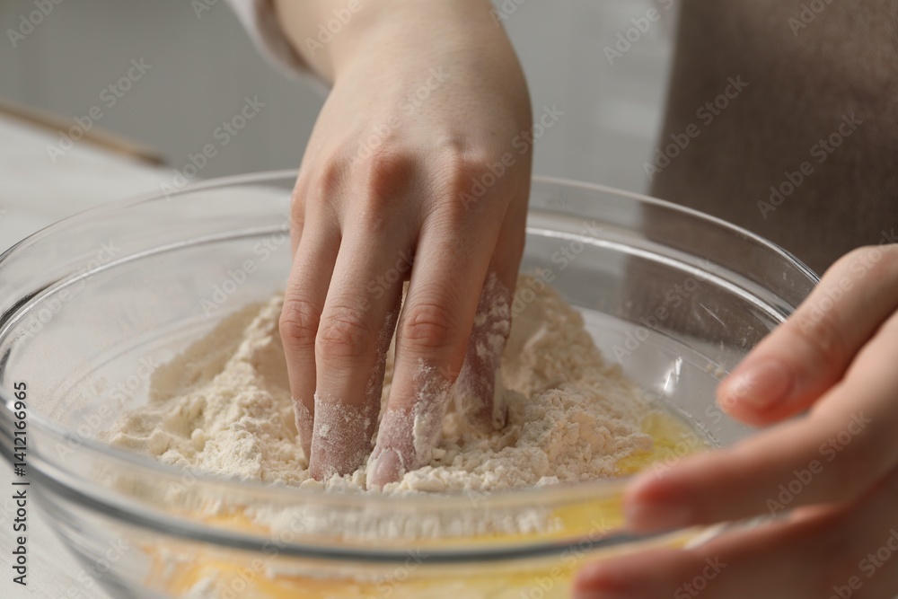 Fototapeta premium Making khinkali. Woman mixing dough at table in kitchen, closeup