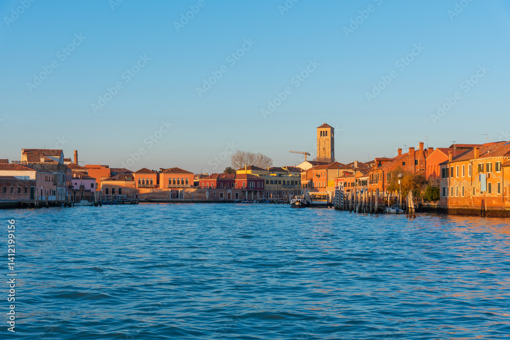 Obraz premium Colorful buildings and bell tower on Murano island at golden hour