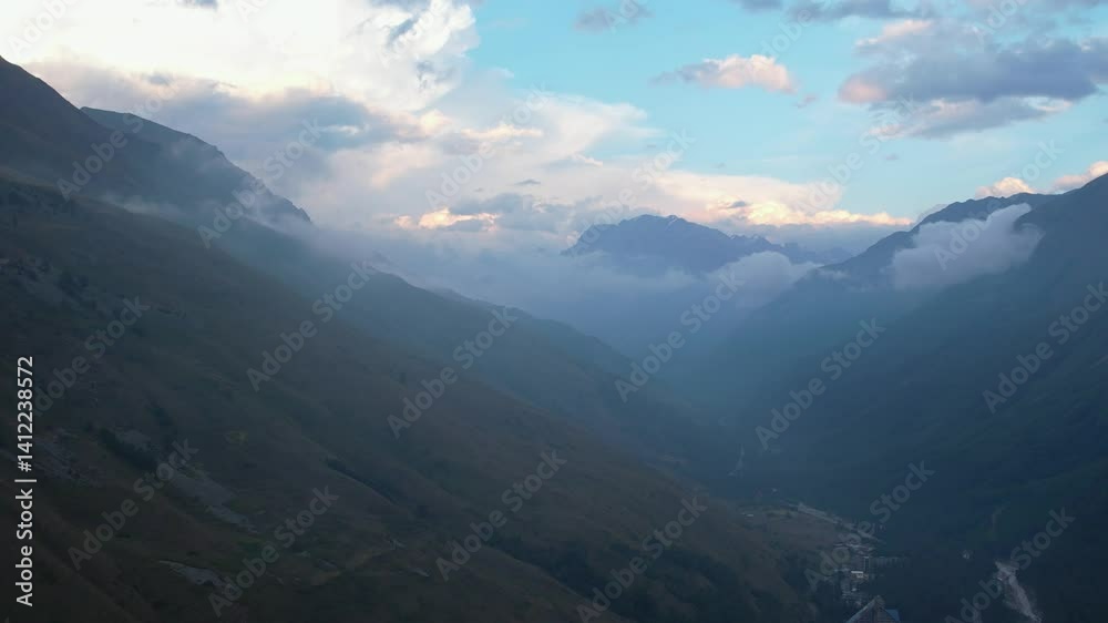 Aerial view of mountain valley with dramatic clouds at dusk Aerial view of mountain valley with dramatic clouds at dusk