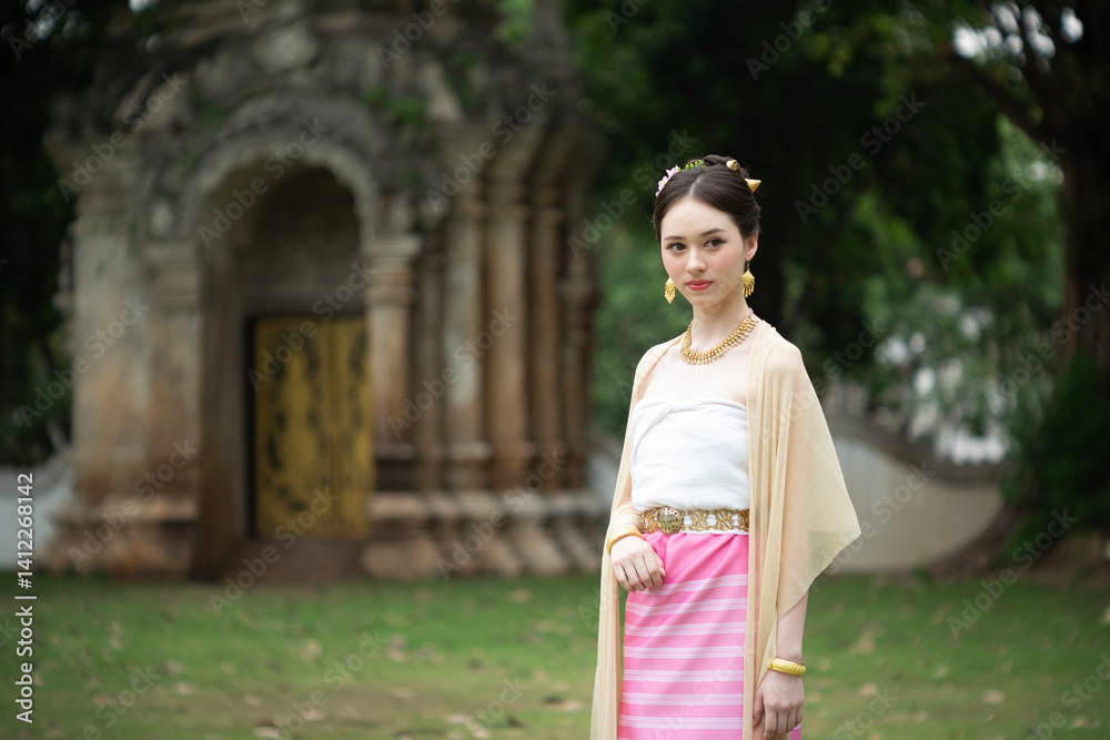 Beautiful young Asean woman in traditional Thai Dvaravati dress in an old temple in Chiang Mai, Thailand.