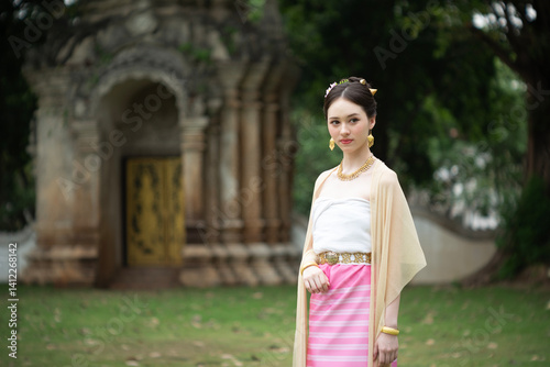 Obraz na płótnie Beautiful young Asean woman in traditional Thai Dvaravati dress in an old temple in Chiang Mai, Thailand. w salonie