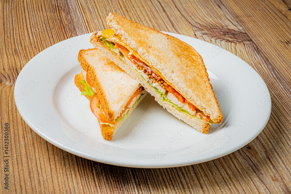 A hearty sandwich filled with fresh vegetables and meats sits invitingly on a plate A hearty sandwich filled with fresh vegetables and meats sits invitingly on a plate