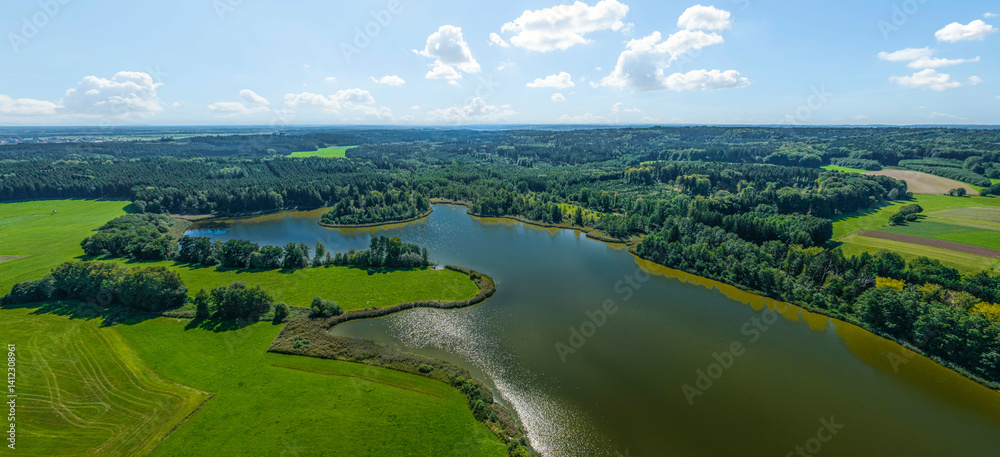 Ausblick auf die Hügellandschaft der Stauden rund um den Schnerzhofener Weiher im Unterallgäu