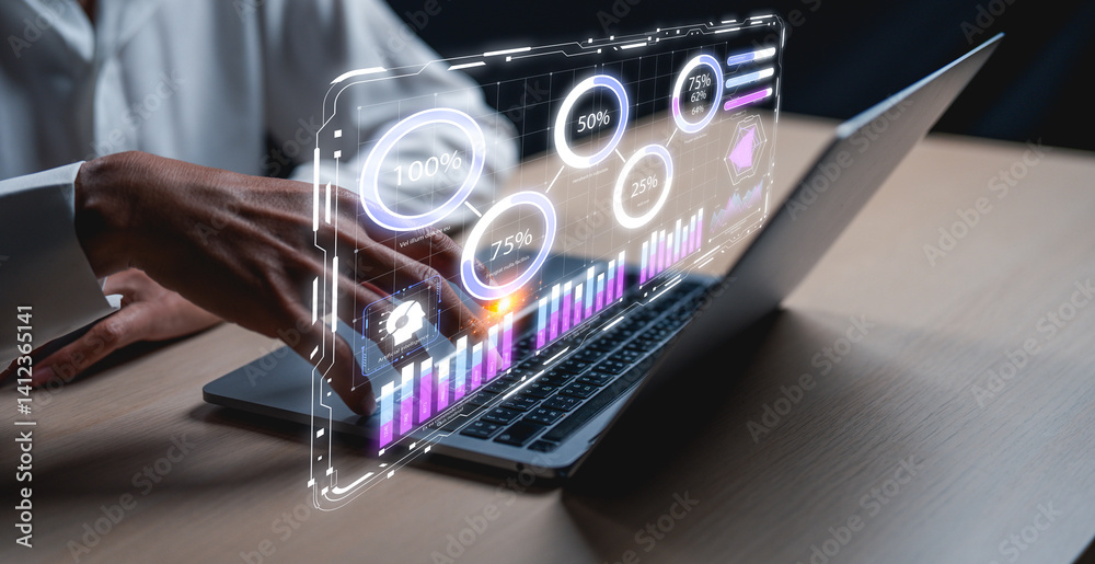 Fototapeta premium A hand interacts with a futuristic display of graphs and data hovering above a laptop, illustrating technology and data analysis.