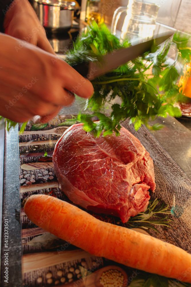 Man with fork in motion with raw beaf steak, carrot and parsley on cutting board. Raw meat, herbs and vegetable on table. Meat preparation in motion. Steak preparation process. Food styling.