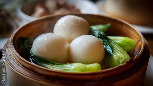 Mouthwatering Steamed Dace Fish Balls Served with Fresh Bok Choy in a Bamboo Basket for a Culinary Delight