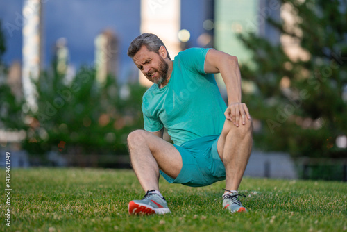 Broken knee after workout. Leg hurt during jogging. Injured man holding knee. Legs pain after running. Man suffering from knee injury. Workout leg pain. Jogging leading to knee trauma. Legs pain.