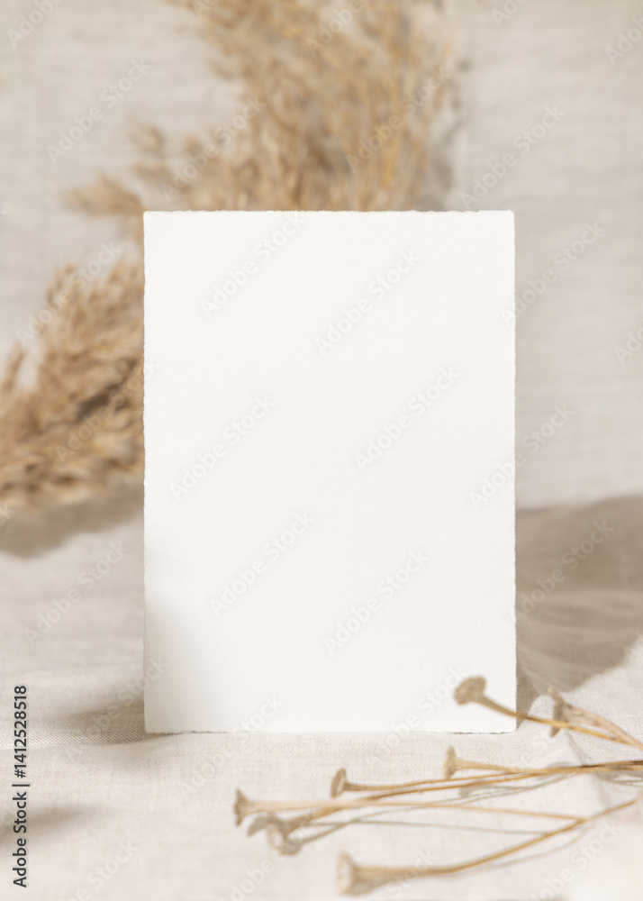 Blank card near dry beige pampas grass on linen closeup, mockup. Bohemian wedding stationery