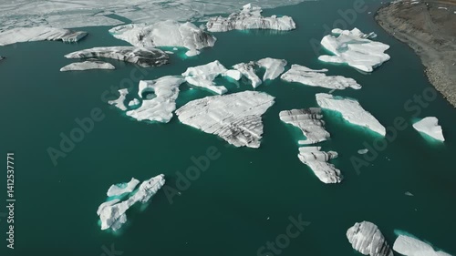 Jökulsárlón Glacier Lagoon, Iceland - Cinematic Drone Orbit of Floating Icebergs with Distant Tourists and Birds - Ice Formations on Deep Blue Water - Vatnajökull National Park, Vatnajökulsþjóðgarður