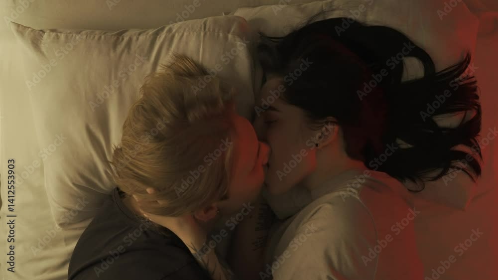 Top view young loving couple romantic time in bedroom. Man and woman half naked sensual lovers laying in bed together, passion, intimacy kissing, foreplay and bonding.