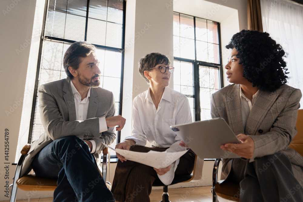 Fototapeta premium Businesspeople discussing during a meeting using tablet and documents