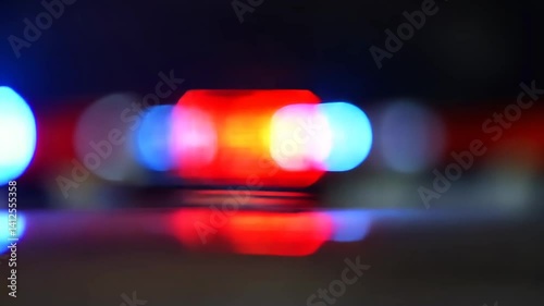 Blurry police lights reflecting on surface.