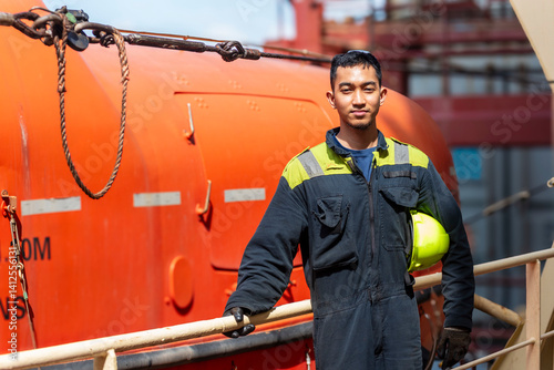 Quadro su tela Portrait of a young Filipino marine engineer standing by the lifeboat on a merchant ship, beginning his weekly safety inspection with focus and a sense of responsibility