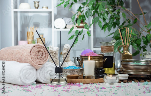 Spa treatment with candles and towel on wooden table, close up