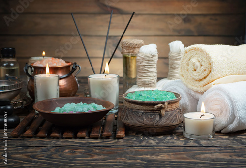 Spa treatment with candles and towel on wooden table, closeup