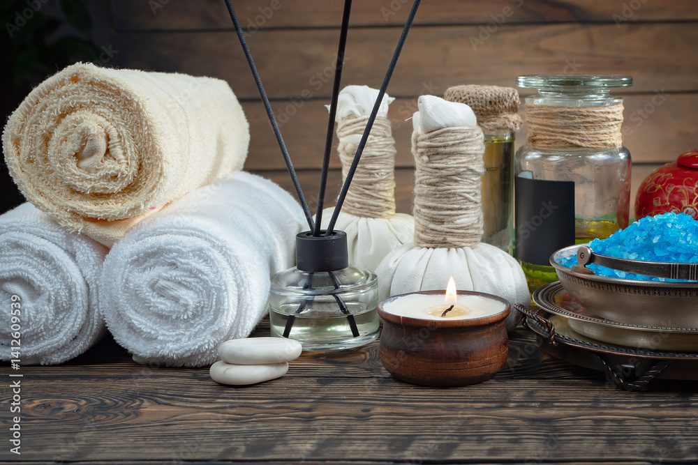 Spa treatment with candles and towel on wooden table, closeup
