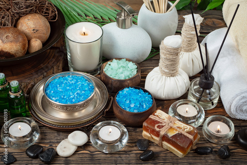 Spa treatment with candles and towel on wooden table, closeup