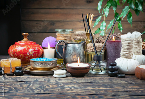 Spa treatment with candles and towel on wooden table, closeup
