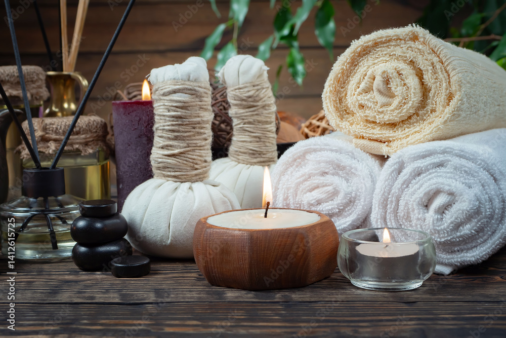 Spa treatment with candles and towel on wooden table, closeup